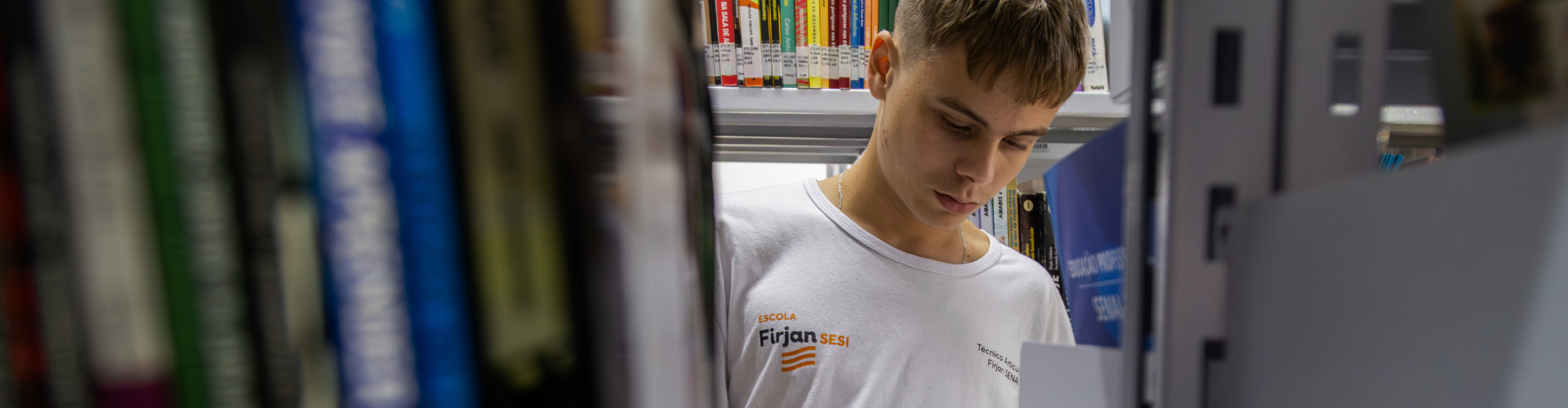 garoto de cabelos claros atrás de uma prateleira de livros
