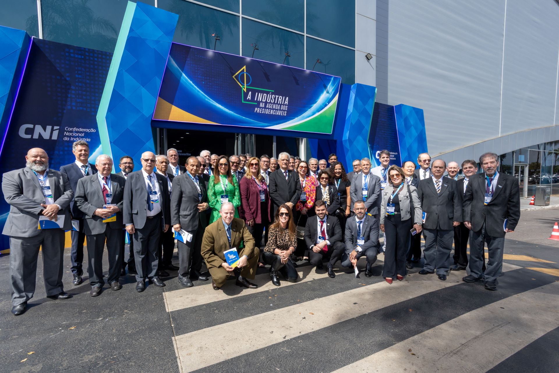 Foto em grupo de comitiva empresarial reunida na entrada do evento 'A Indústria na Agenda dos Presidenciáveis', da CNI.
